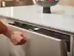 Henkilö koputtaa astianpesukonetta, että se avautuu. Knock2Open toiminnallisuus avaa oven koputtamalla.
