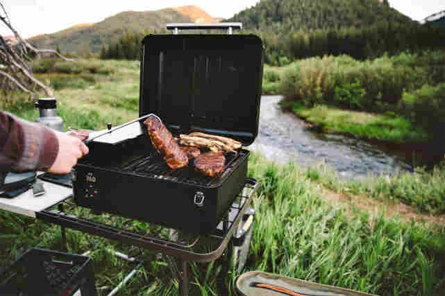 Traeger Ranger -matkagrilli on käytössä joen vierellä metsä maisemissa