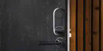 Black Yale smart lock installed on a dark door with a wooden frame.
