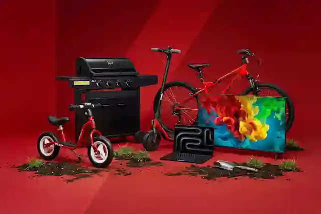 Punaisella taustalla valikoima ajankohtaisia tuotteita: sähköpotkulauta, polkupyöriä, kaasugrilli, televisio ja kannettava tietokone.