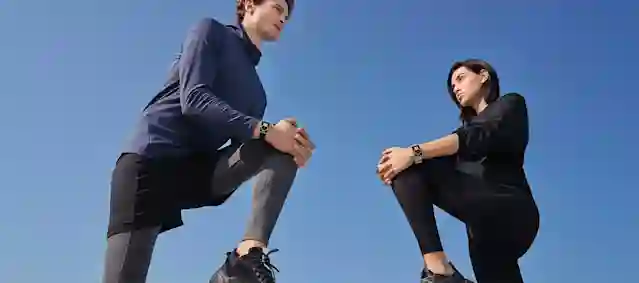 Huawei Watch Fit -aktiivisuusrannekeet kahdella urheilijalla kädessä. Ostoksille.