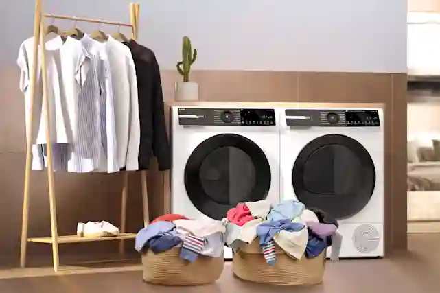 Pyykinpesukone ja kuivausrumpu pyykkien vieressä.