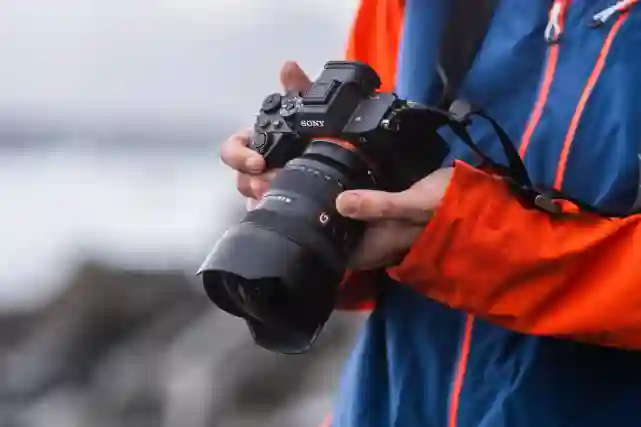 Mies katsoo kameran näytöstä ottamaansa kuvaa rannalla. Tutustu Verkkokauppa.comin kameroihin!