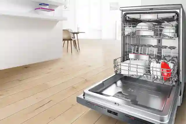 Astianpesukone auki keittiössä, jonka sisällä tiskejä.