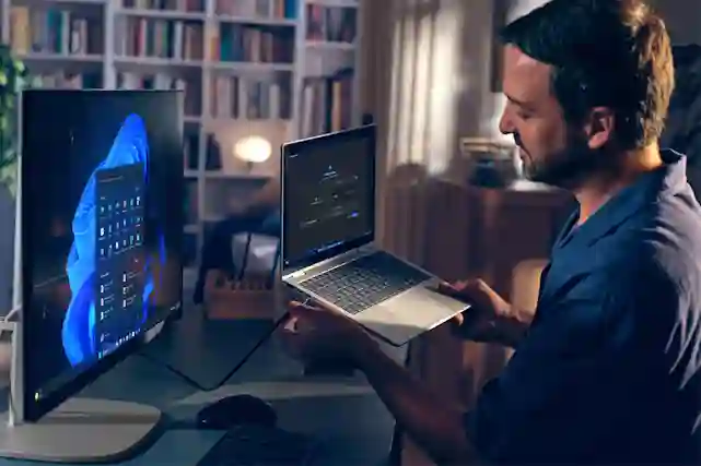 Mieshenkilö kytkee HP kannettavaa HP:n näyttöön kotitoimistolla.