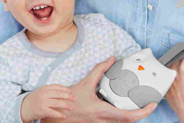 Iloista lasta pidetään sylissä. Kädessä myös vauva arkea helpottamaan suunniteltu elektroniikka laite, joka on pöllön muotoinen. Tutustu lisää näihin tuotteisiin!