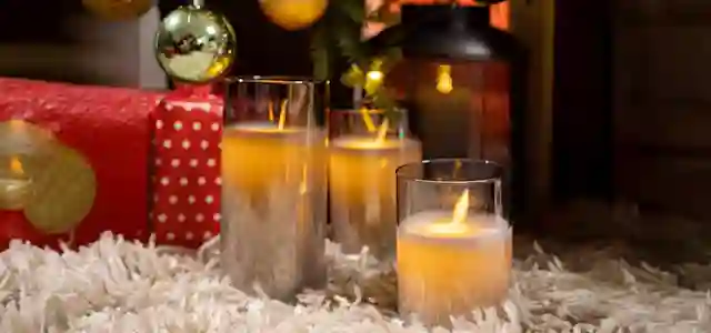 LED-kynttilöitä taljalla. Vieressä pari joululahjaa ja joulukoristeita. Kuvaa jatkettu tekoälytyökalun avulla.