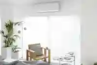 Ilmalämpöpumppu makuuhuoneen ikkunan yläpuolella, skandinaavisesti sisustetussa kodissa.