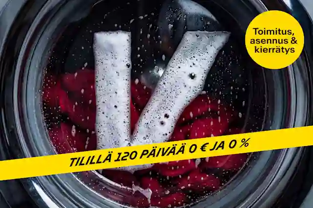 Pesukoneen rummun sisäpuoli ylhäältä kuvattuna; vaahtoutunut pesuaine muodostaa V-kirjaimen punaisia vaatteita vasten, ja kuvan päällä on keltainen ilmoitusnauha tekstillä ”Tilillä 120 päivää 0 € ja 0 %”.