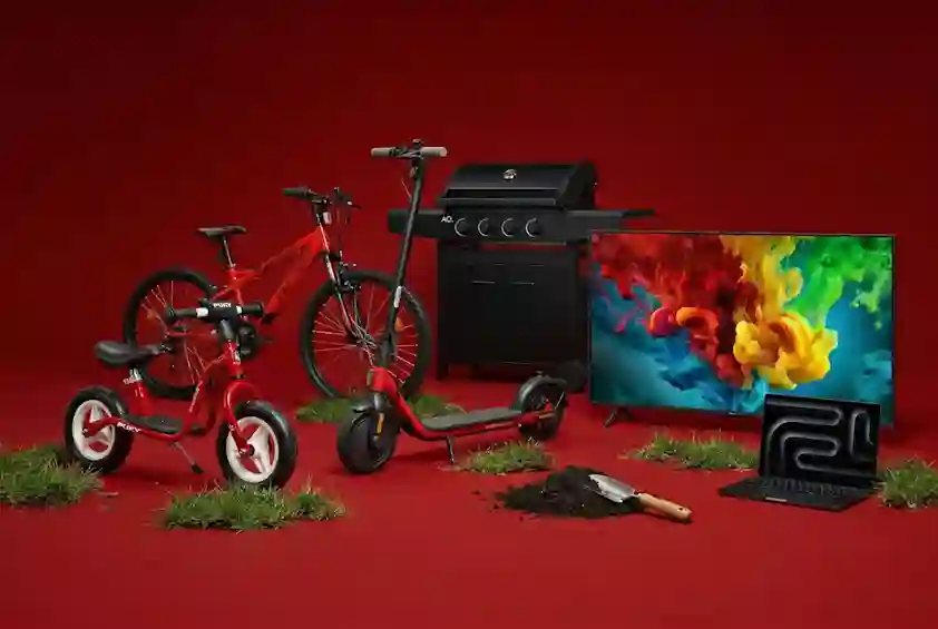 Punaisella taustalla valikoima ajankohtaisia tuotteita: sähköpotkulauta, polkupyöriä, kaasugrilli, televisio ja kannettava tietokone.