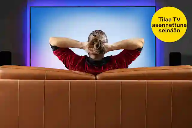 Mies katsoo telkkaria sohvalla ja pitää käsiään niskansa takana. Keltainen pallura vieressä, jossa teksti:"Asennus seinälle 99,99 €". Tutustu tv ja video tuotteisiin!