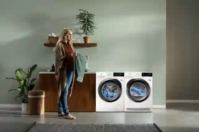 Nainen käsittelee puhdasta pyykkiä pyykinpesutiloissa.