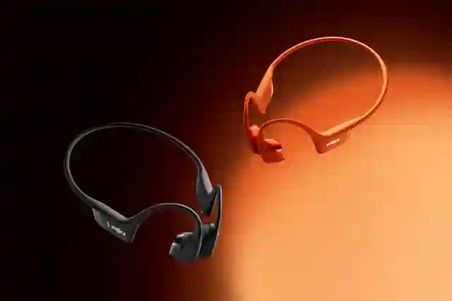 Kaksi Shokz luujohde urheilukuuloketta. Musta ja oranssi.