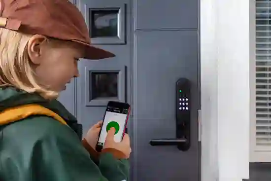 Tyttö puhelimellaan oven ulkopuolella, jossa koodillinen älylukko.