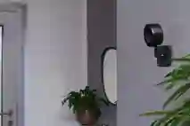 EVE merkkinen musta valvontakamera asetettu talon harmaalle sisäseinälle.