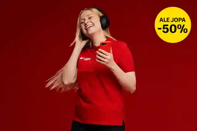 Hymyilevä nainen punaisessa Verkkokauppa.com-paidassa kuuntelee musiikkia mustilla kuulokkeilla ja pitää punaista puhelinta.