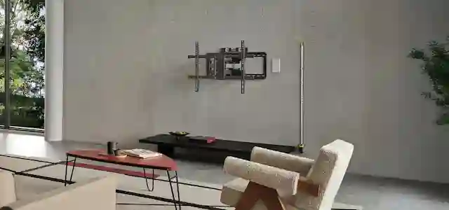 Olohuone, jossa seinälle asennettu tv:n seinäteline; Mittanauhalla ja lyijykynä viivoilla havainnollistetaan katseluetäisyyttä ja television sijoituskorkeutta suhteessa istuimiin.