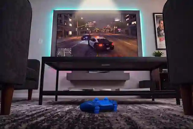 Sininen Playstation 5 Dualsense -peliohjain lattialla television edessä, ruudulla näkyy takaa-ajopeli kaupunkiympäristössä.