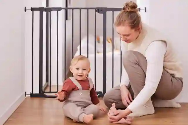 Äiti ja vauva leikkivät yhdessä turvaportilla varustetun lastenhuoneen lattialla.