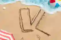 Hiekkaan on piirretty V-logo tikulla joka löytyy piirroksen vierestä. Ranta aallot tulevat vähän piirroksen päälle.