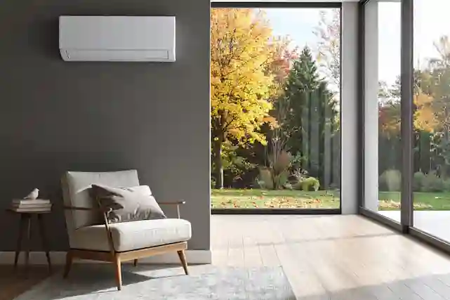 Olohuoneen seinällä ilmalämpöpumppu, ikkunassa syksyinen maisema.