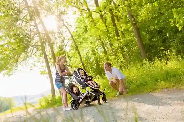 Perhe kävelyllä lountopolulla. Lapset istuvat Hauckin tuplarattaissa.