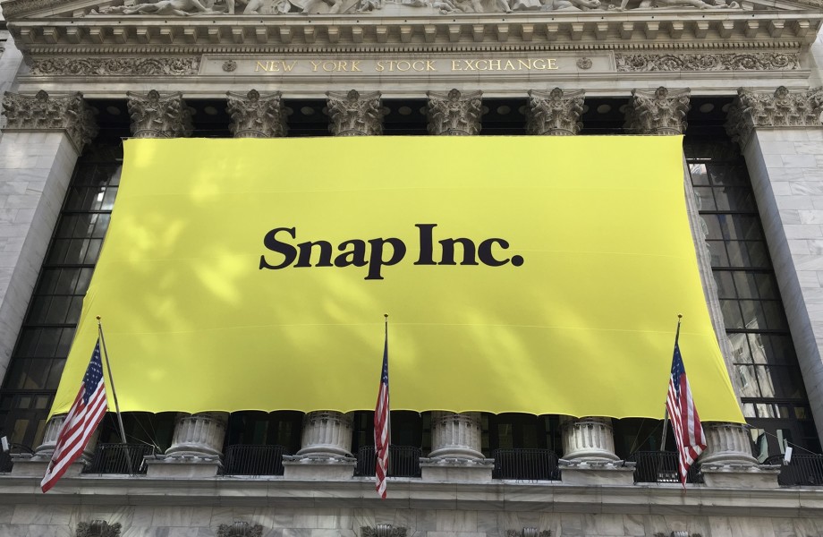 Image of a large yellow Snap Inc. banner hung on the front of the New York Stock Exchange building from the day Snap Inc. went public as a company.  