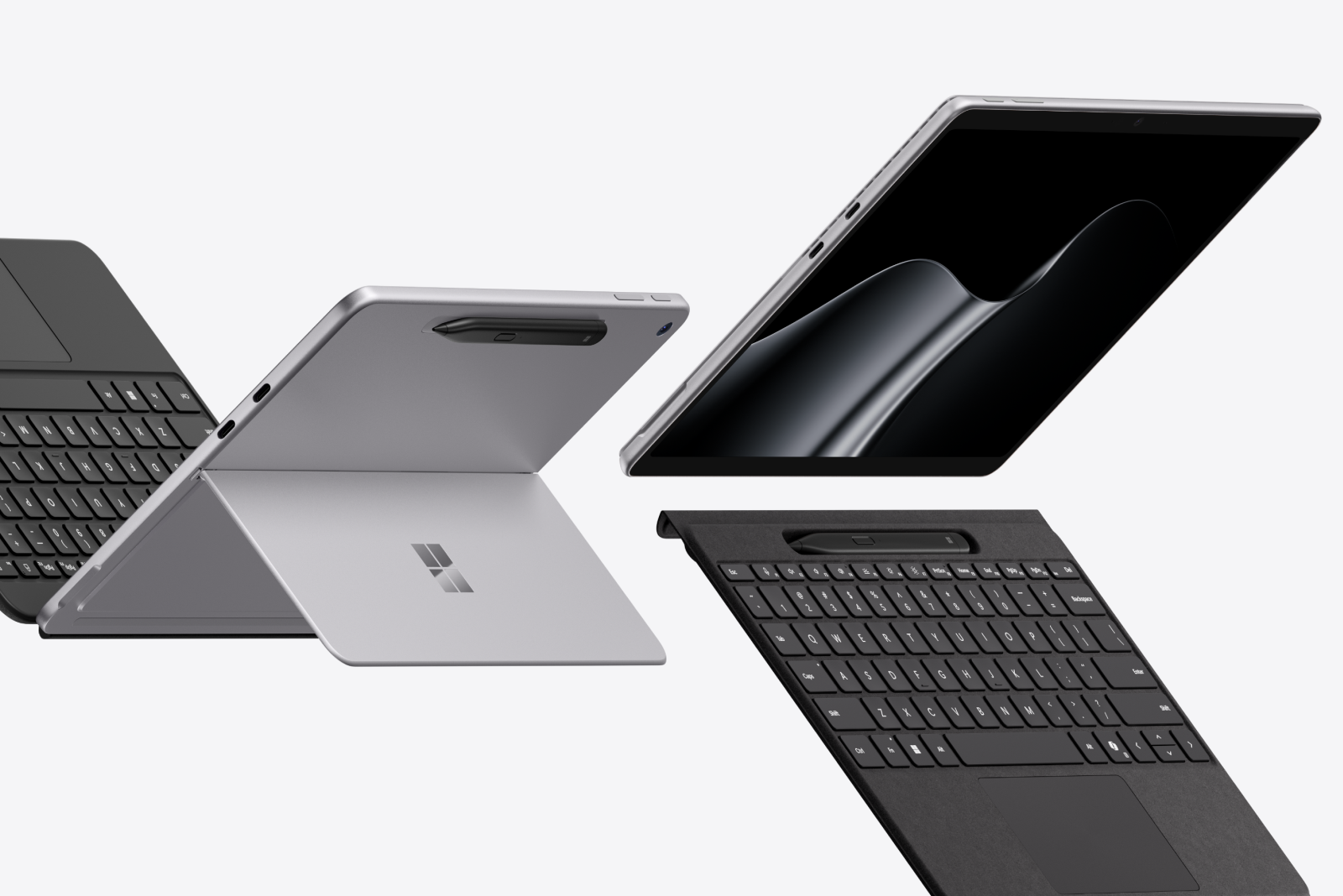 An open 2-in-1 displaying the dark ribbon image with detachable keyboard and stylus dramatically tipped against a gray background
