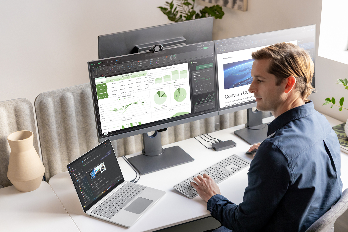A man works on a Surface device at his desk