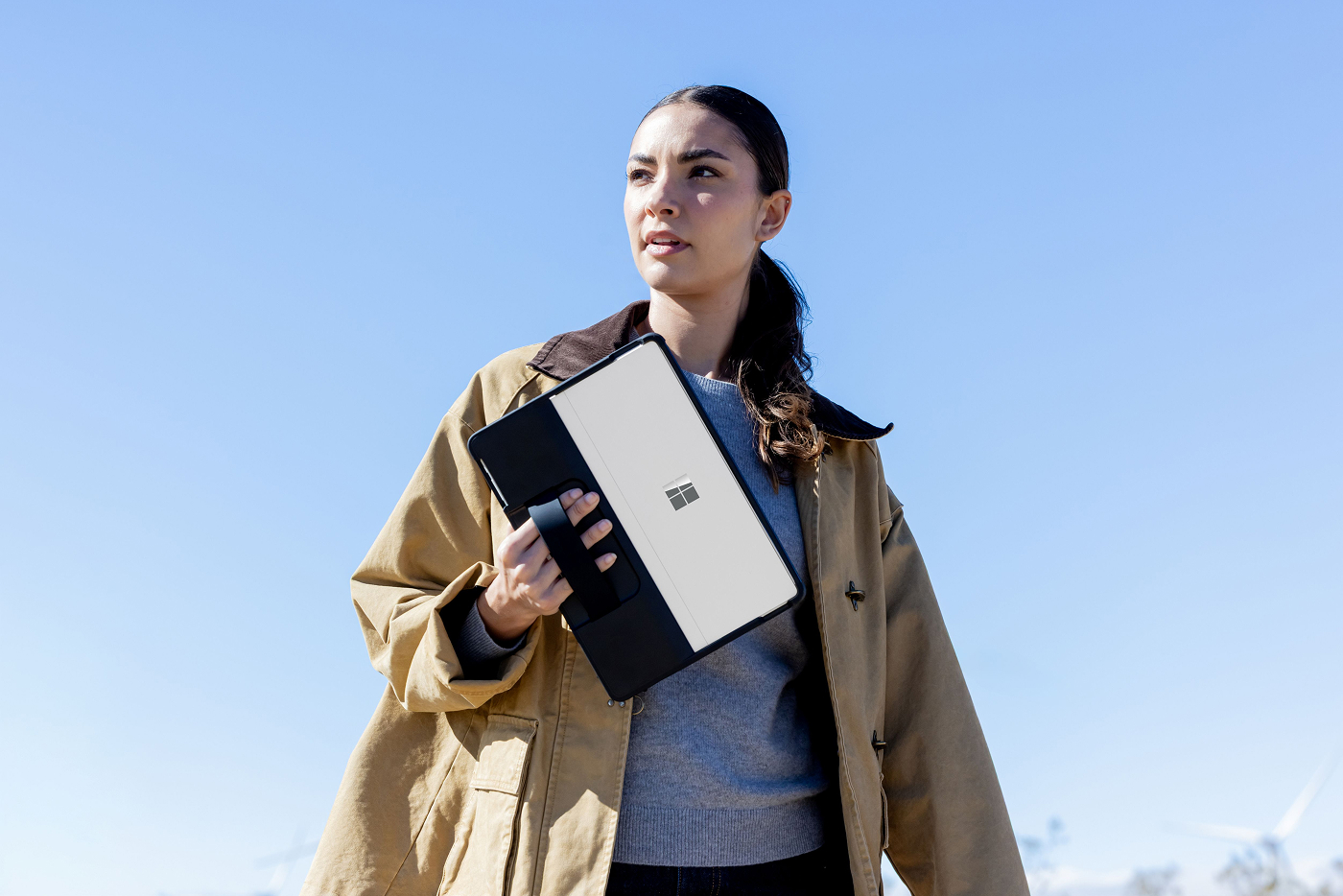 A woman outside carrying a Surface Pro