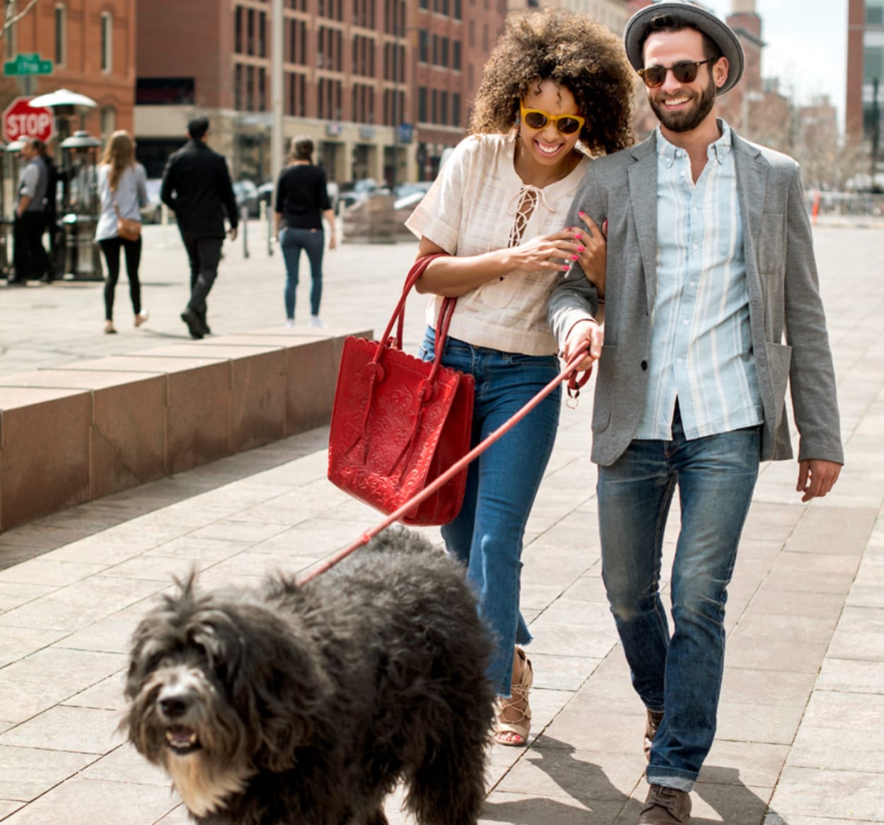 Couple walking their dog on a city sidewalk
