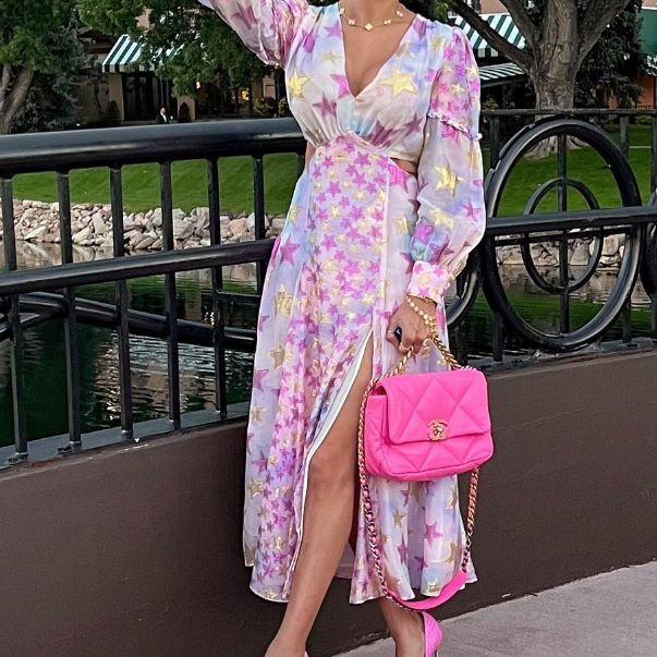 a woman in a pink floral dress holding a pink Chanel 19 bag