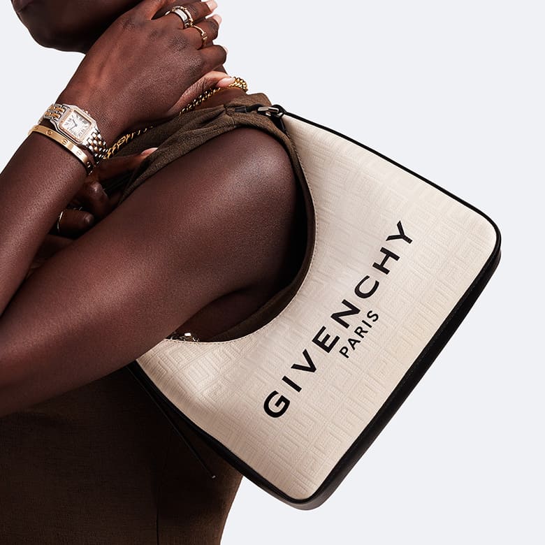 a woman in a brown sleeveless dress holding a Givenchy logo 4G Small Moon Cut Shoulder Bag in cream