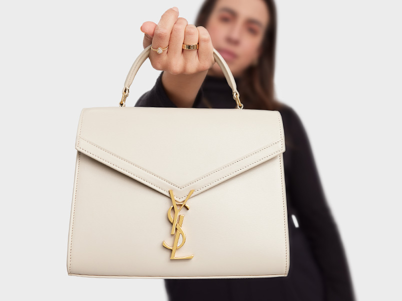 A woman holding a silver YSL handbag.