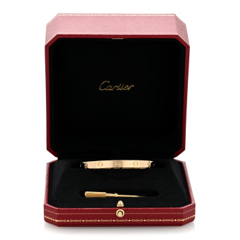 yellow gold Cartier Love bracelet sitting in a red Cartier case