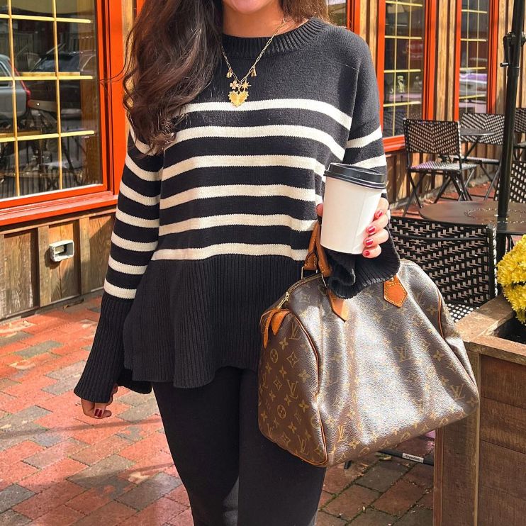 woman in black and white striped sweater holding a Louis Vuitton Monogram Speedy