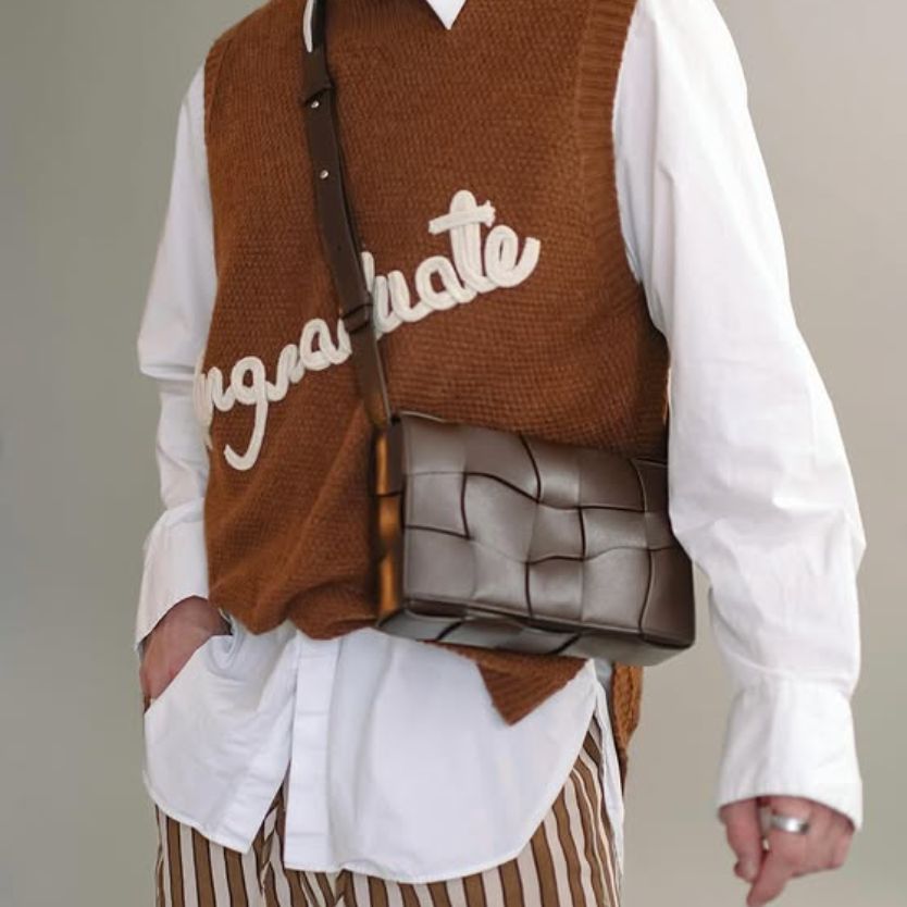 a man in a white button down long sleeve shirt and brown sweater vest wearing a brown Bottega Veneta Cassette