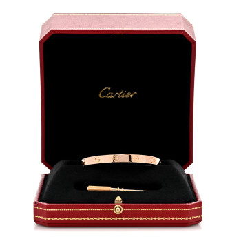 a rose gold Cartier Love bracelet sitting in a red Cartier case