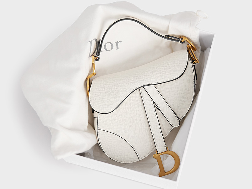 An image of a white Christian Dior Saddle bag in a box.