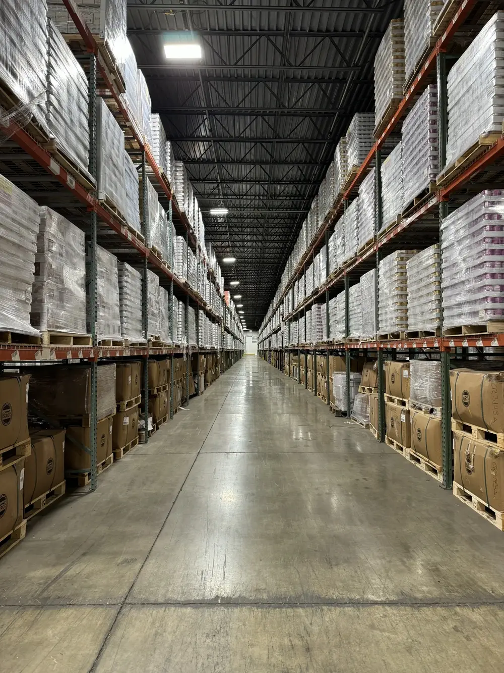 warehouse-interior-stacks-of-canned-foods-on-and-boxes-shelves-deep-walkway-perspective-shot