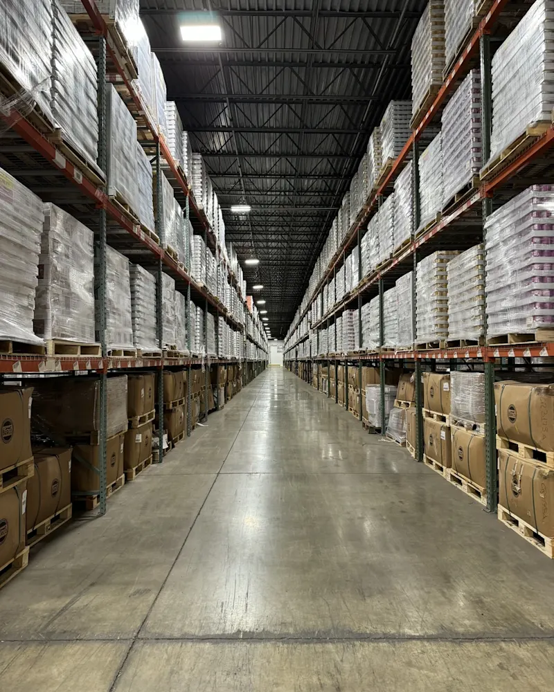 warehouse-interior-stacks-of-canned-foods-on-and-boxes-shelves-deep-walkway-perspective-shot
