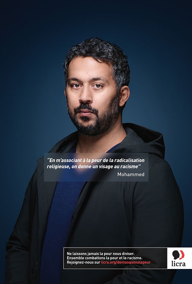 A man standing in front of a blue background