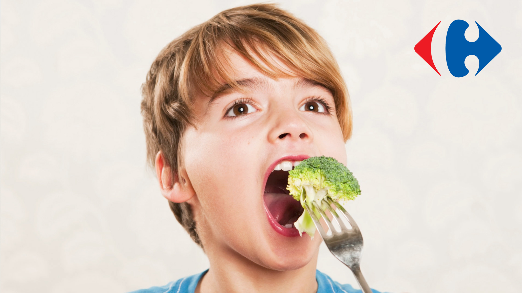 A boy eating a broccoli