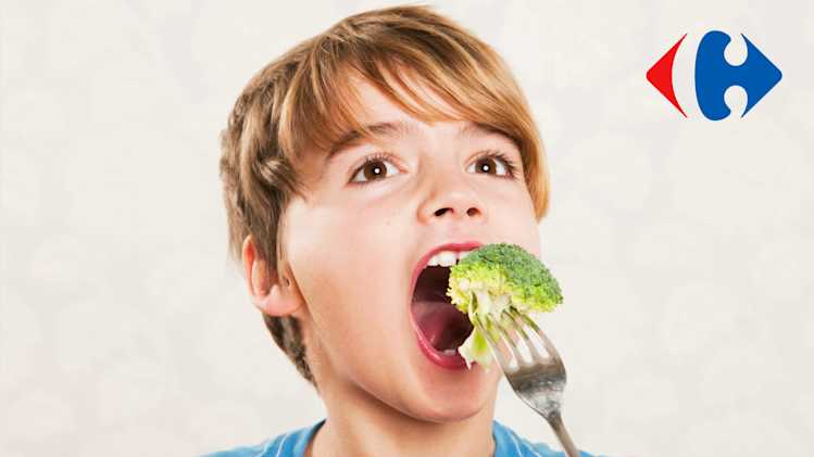 A boy eating a broccoli