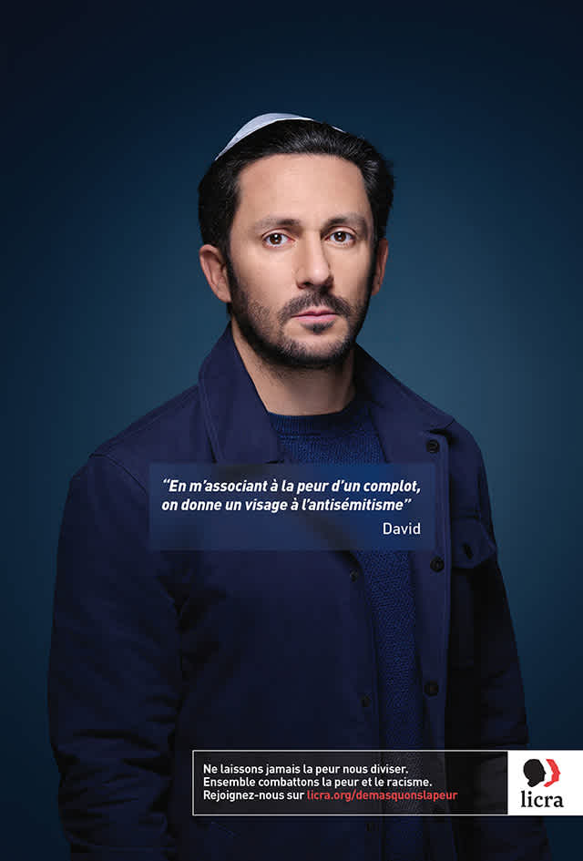 A man standing in front of a blue background