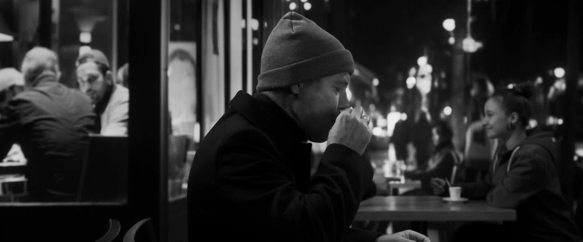 Un homme boit son café en terrasse