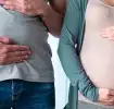 Homem e mulher com a barriga na mão