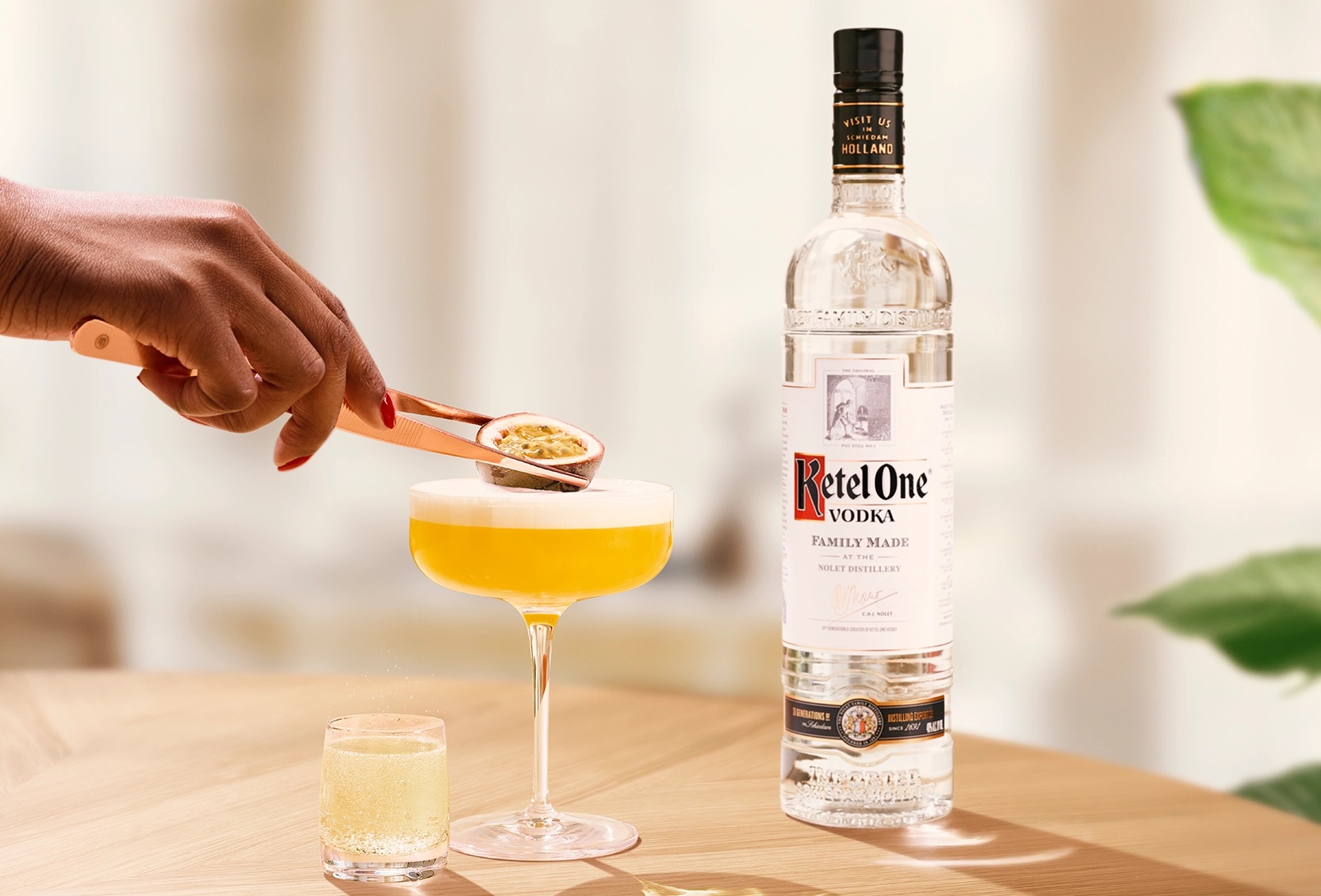 Martini Ketel One au fruit de la passion dans une coupe avec un zeste de citron pressé à la main