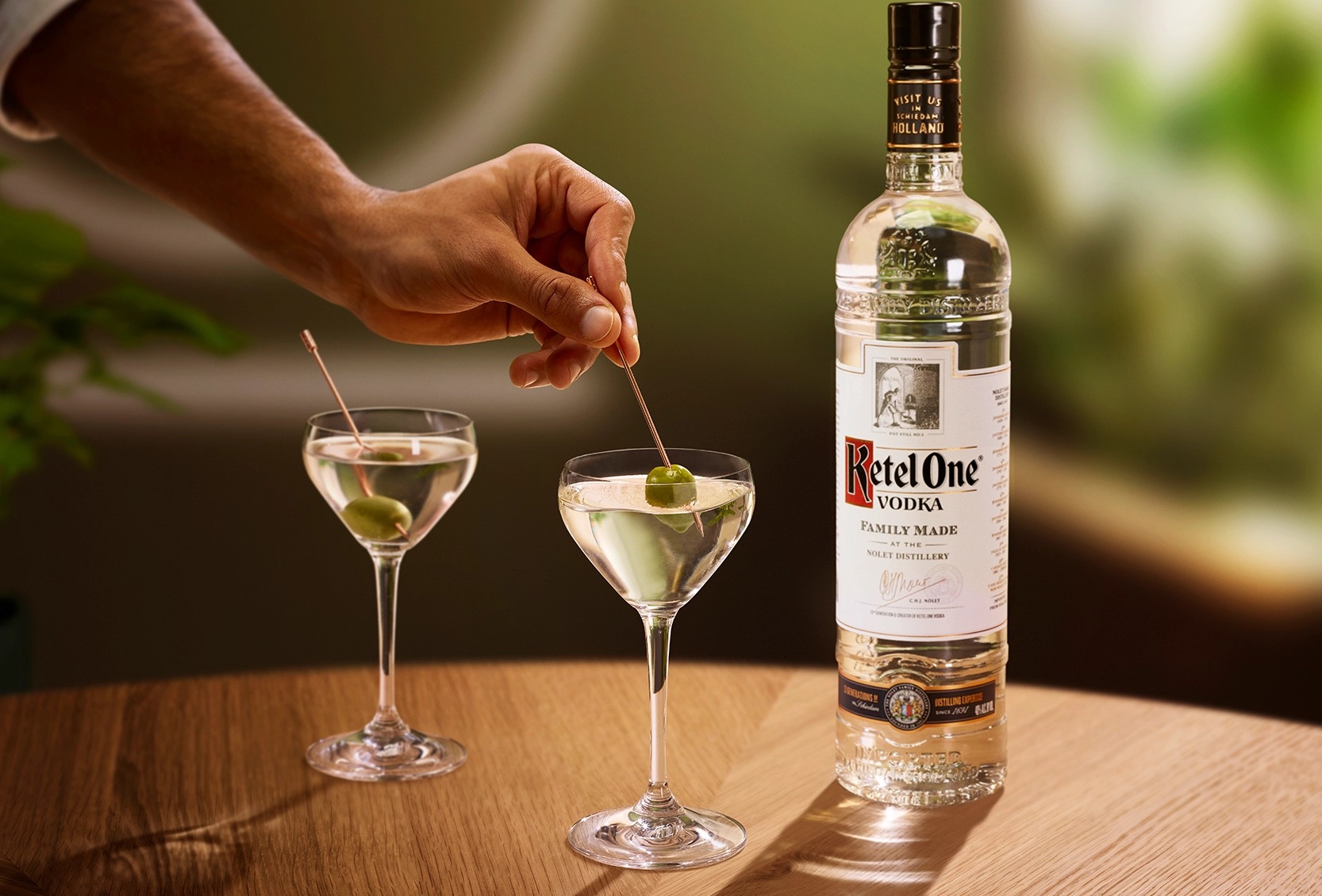 Dirty Martini Ketel One dans un verre Nick & Nora avec une olive ajoutée à la main