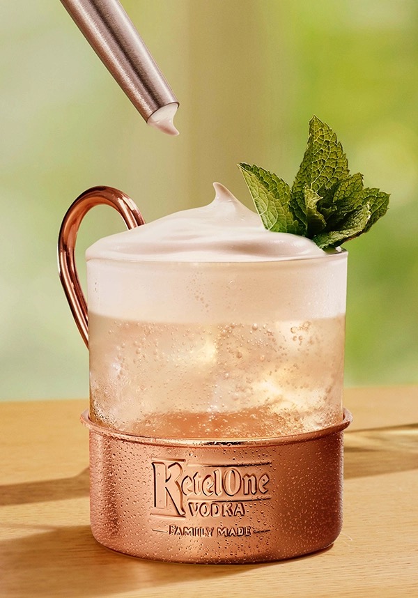 Brazil Mule Ketel One dans une tasse en verre avec de la crème ajoutée à la main